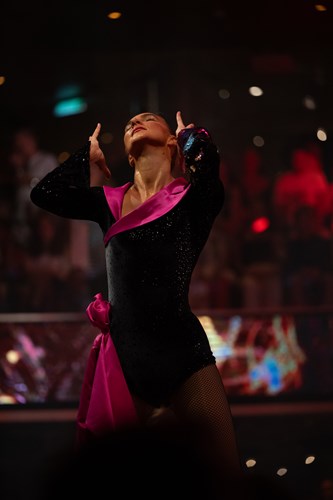 Rachael Boggiano in a dance position wearing a black leotard with deep pink satin sash and collar